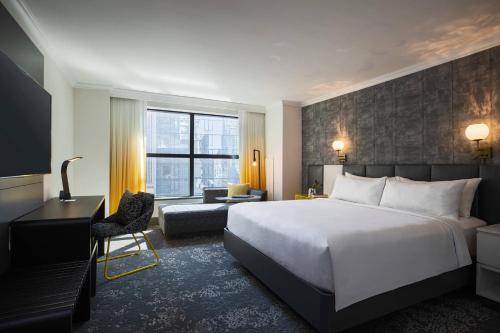 a hotel room with a bed and a desk and a chair at Renaissance New York Times Square Hotel by Marriott in New York