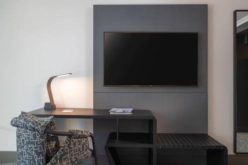 a room with a desk with a tv and a chair at Renaissance New York Times Square Hotel in New York