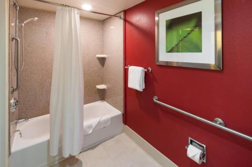 uma casa de banho com uma parede vermelha e um chuveiro em Courtyard by Marriott Jackson Ridgeland em Jackson