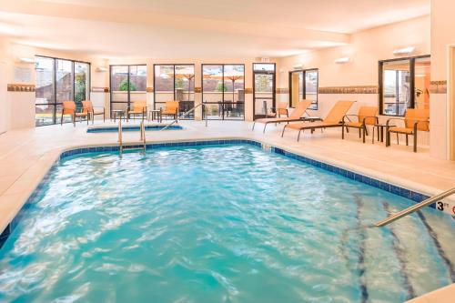 a pool in a hotel with chairs and tables at Courtyard by Marriott Stafford Quantico in Triangle