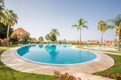 una grande piscina in un cortile con palme di Los Lagos de Santa Maria Golf a Marbella