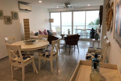 a dining room and living room with a table and chairs at Apartamento en Torres del Sun Rise San Andres Islas Colombia in San Andrés