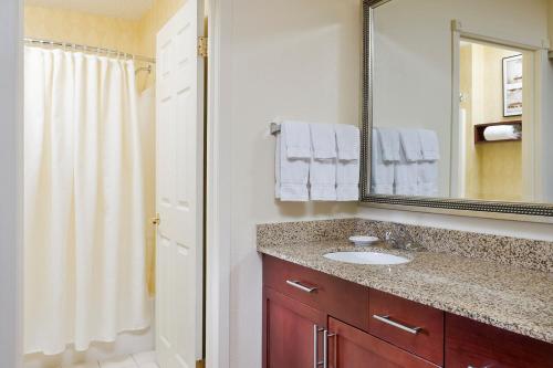 a bathroom with a sink and a mirror and a shower at Residence Inn by Marriott Peoria in Peoria