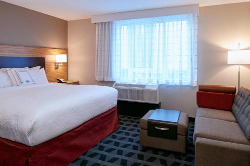 a hotel room with a bed and a couch at TownePlace Suites by Marriott Jackson in Jackson
