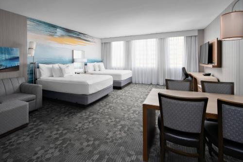 a hotel room with a bed and a living room at Courtyard by Marriott Edmonton Downtown in Edmonton