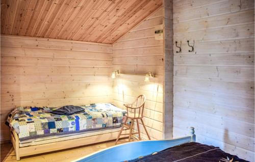 Habitación de madera con cama y silla. en 2 Bedroom Amazing Home In Sderkping en Söderköping