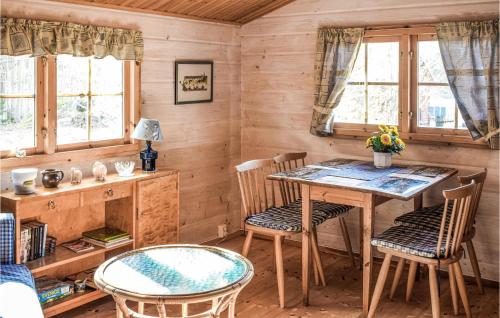 een eetkamer met een tafel, stoelen en ramen bij 2 Bedroom Amazing Home In Sderkping in Söderköping