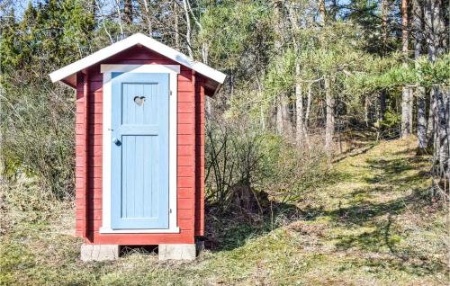 a red and blue out house with a blue door at 2 Bedroom Amazing Home In Söderköping in Söderköping