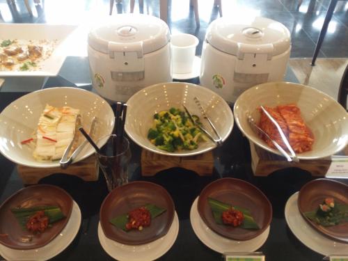 a table topped with plates of food and toasters at Seogwipo KAL Hotel in Seogwipo