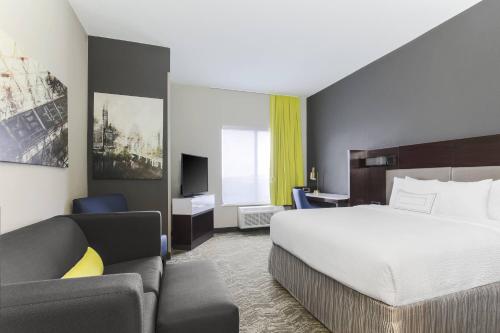 SpringHill Suites by Marriott Austin Parmer/Tech Ridge في أوستن: غرفه فندقيه بسرير واريكه