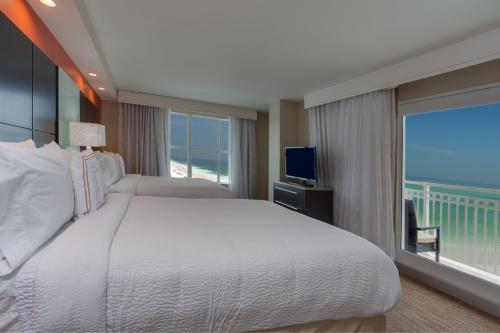 デイトナビーチにあるResidence Inn by Marriott Daytona Beach Oceanfrontのベッドルーム(大型ベッド1台、大きな窓付)