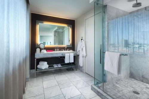 a bathroom with a shower and a sink and a mirror at W Hollywood in Los Angeles