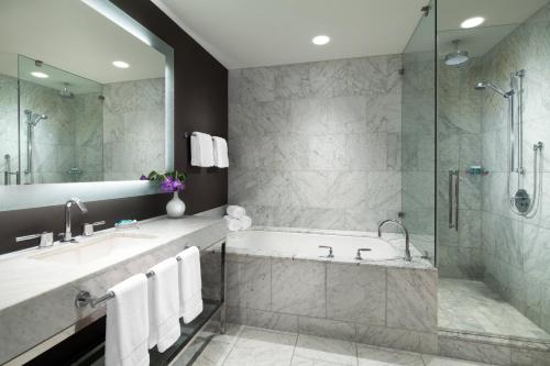 a bathroom with a tub and a sink and a shower at W Hollywood in Los Angeles