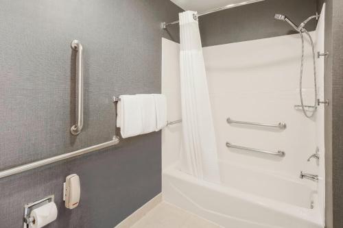 uma casa de banho com um chuveiro e uma banheira branca em Residence Inn Chicago Deerfield em Deerfield