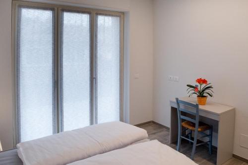 a bedroom with a bed and a desk and a window at Ca’ del Riccio Blu in Bra
