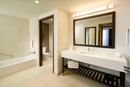 a bathroom with a sink and a tub and a mirror at Courtyard by Marriott Hermosillo in Hermosillo