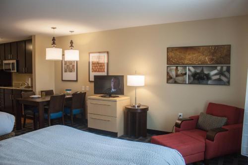 a hotel room with a bed and a dining room at TownePlace Suites by Marriott Beaumont Port Arthur in Port Arthur