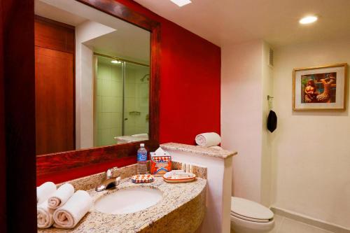 a bathroom with a sink and a toilet and a mirror at Courtyard Toluca Airport in Toluca