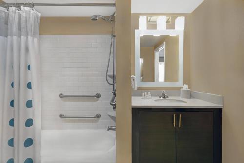 uma casa de banho com um chuveiro, um lavatório e um espelho. em TownePlace Suites Republic Airport Long Island Farmingdale em Farmingdale