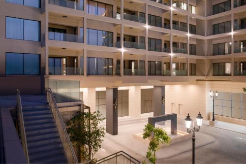 an external view of a building at night at Agora, Doha, Autograph Collection in Doha