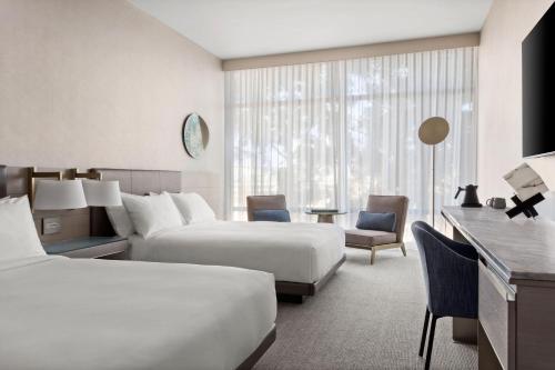 a hotel room with two beds and a desk at TETRA Hotel, Autograph Collection in Sunnyvale