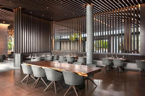 a dining room with a wooden table and chairs at TETRA Hotel, Autograph Collection in Sunnyvale