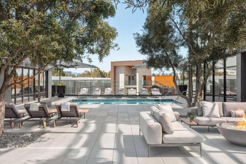 a patio with a pool with couches and chairs at TETRA Hotel, Autograph Collection in Sunnyvale