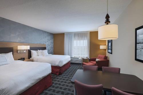 a hotel room with two beds and a table at TownePlace Suites by Marriott Naples in Naples