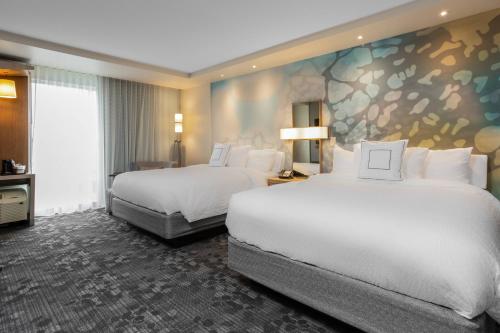 a hotel room with two beds and a mural at Courtyard by Marriott Jonesboro in Jonesboro