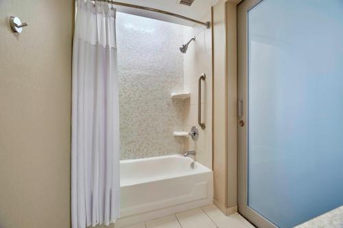 a bathroom with a tub and a shower curtain at SpringHill Suites by Marriott Las Vegas Convention Center in Las Vegas