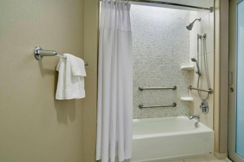 a bathroom with a white shower curtain and a bath tub at SpringHill Suites by Marriott Las Vegas Convention Center in Las Vegas