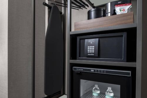 a microwave and a oven with water bottles in it at AC Hotel by Marriott Miami Dadeland in Miami