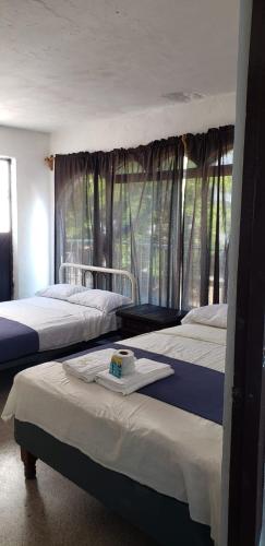 a bedroom with three beds and a window at Casa Costa Brava in Acapulco