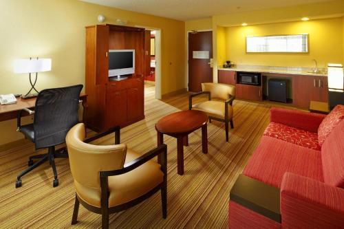 a hotel room with a desk and a living room at Country Inn & Suites by Radisson, Convention Center in Altoona
