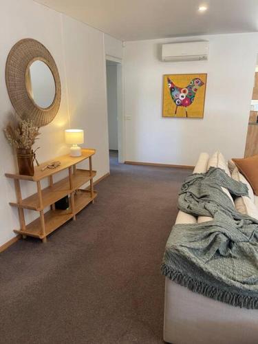 a living room with a couch and a mirror at Yellow Door Villa in Barwon Heads