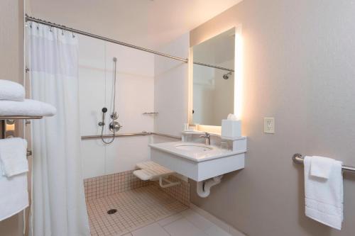 y baño blanco con lavabo y ducha. en SpringHill Suites Grand Rapids North, en Grand Rapids