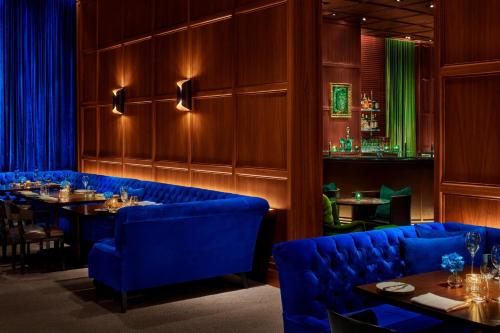 a restaurant with blue chairs and tables in a room at The Times Square EDITION New York in New York