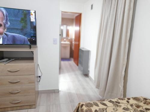 um quarto com uma televisão numa cómoda com uma cama em Monseñor Fagnano 592 "5" em Ushuaia