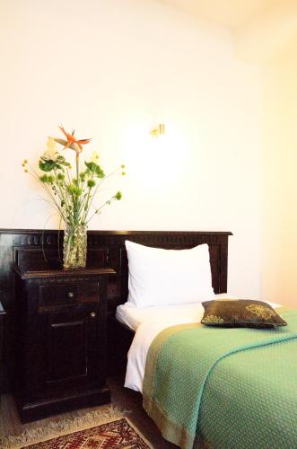 a bedroom with a bed and a plant on a dresser at Hotel Belleville in Iaşi