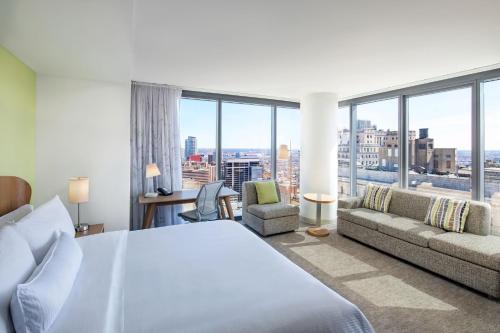 a bedroom with a bed and a couch and windows at Element Philadelphia Downtown in Philadelphia