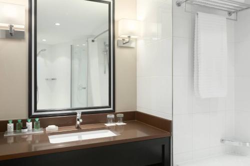 a bathroom with a sink and a mirror and a shower at Renaissance Amsterdam Hotel in Amsterdam