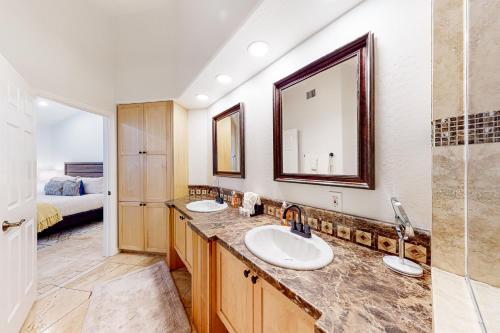 La salle de bains est pourvue de 2 lavabos et d'un grand miroir. dans l'établissement Piestewa Getaway, à Phoenix