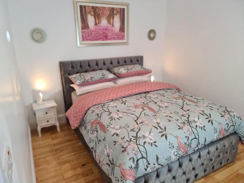 a bedroom with a bed with a gray head board at Dunderry Lodge Self Catering Family Lodges in Navan