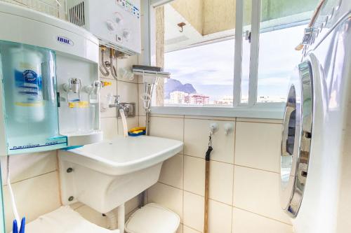 een kleine badkamer met een wastafel en een raam bij Confortável apto 2Qtos c/ Varanda e Vista Mar in Rio de Janeiro