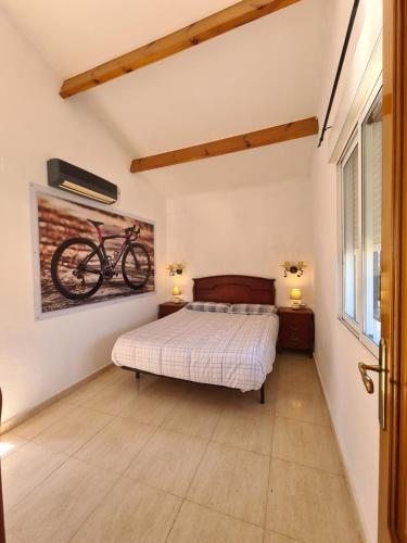 ein Schlafzimmer mit einem Bett und einem Fahrrad an der Wand in der Unterkunft Velo Villa w/ A/C, free Wi-Fi & Pool near Benidorm in Polop