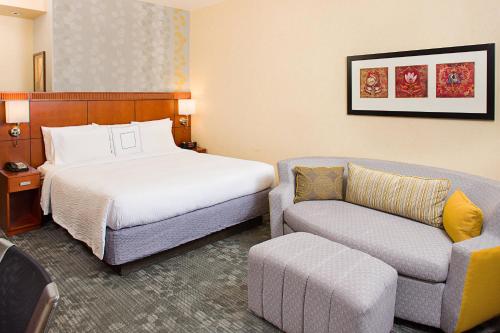 a hotel room with a bed and a couch at Courtyard by Marriott Paso Robles in Paso Robles