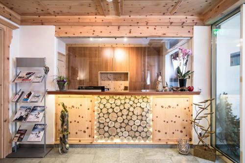 a kitchen with a counter with a wooden wall at Apart Landhaus Heim in Mayrhofen