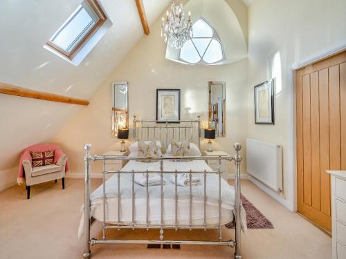a bedroom with a bed and a chandelier at The Old Chapel in Spark Bridge