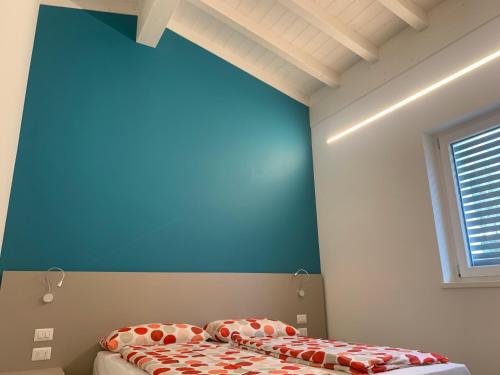 a bedroom with a blue wall and a bed at Appartamento Gardenia in Malcesine