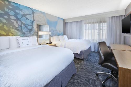 a hotel room with two beds and a desk at Courtyard by Marriott Secaucus Meadowlands in Secaucus